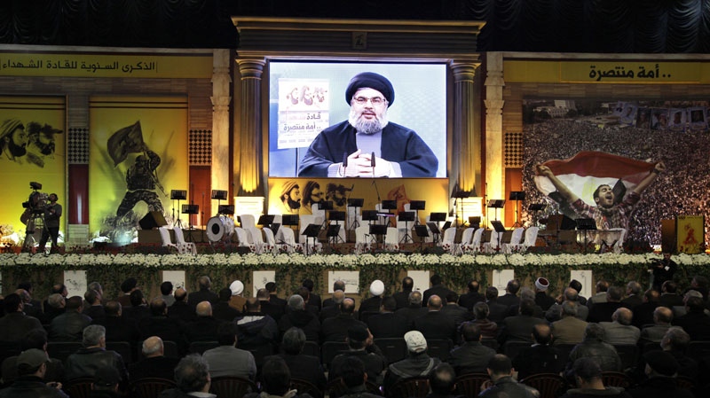 Hezbollah leader Hassan Nasrallah speaks via a video link during a rally commemorating the death of thee Hezbollah leaders, including the 2008 assassination of Hezbollah's top military commander Imad Mughniyeh, in Beirut's southern suburbs of Dahiyeh, Lebanon, Wednesday, Feb. 16, 2011. (AP Photo/Bilal Hussein)