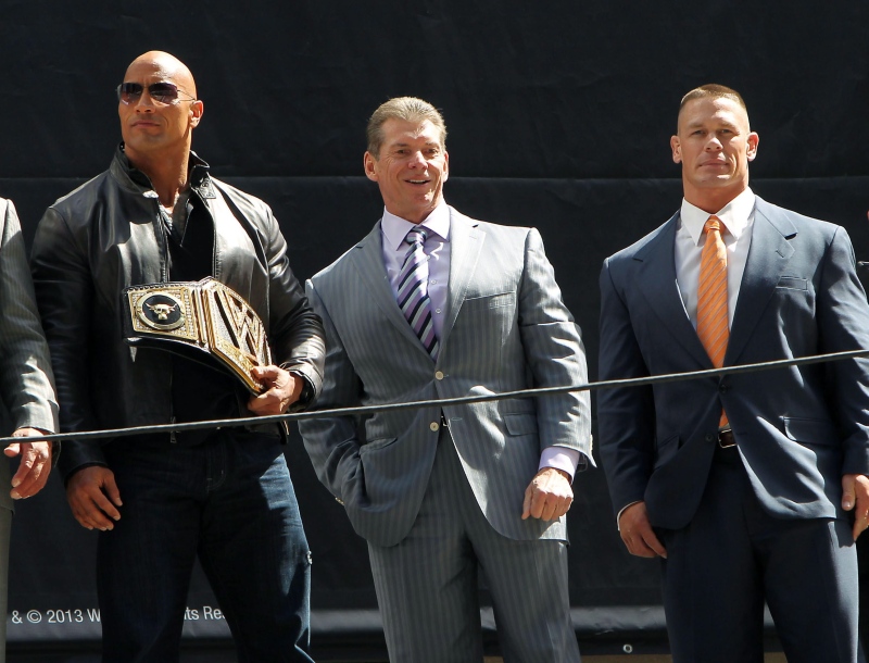 This image released by Starpix shows actor and WWE star Dwayne Johnson, better known as The Rock, left, with Vince McMahon, and WWE star John Cena at a news conference at Radio City Music Hall in New York on Thursday, April 4, 2013. (AP Photo/Starpix, Dave Allocca)