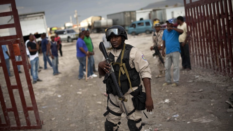 A Haitian police officer guards a gate at the border between The Dominican Republic and Haiti in Malpasse, Haiti, Thursday, Feb. 17, 2011. (AP Photo/Ramon Espinosa)