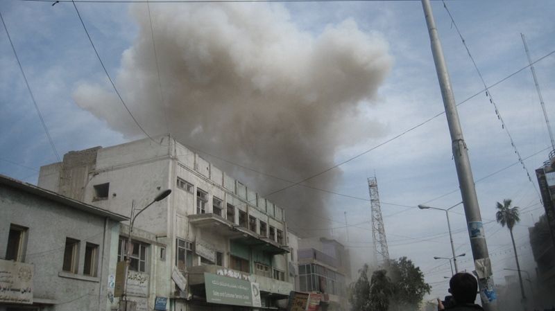 Smoke rises from a bank in Jalalabad, east of Kabul, Afghanistan, Saturday, Feb. 19, 2011. (AP / Shir Shah Hamdard)