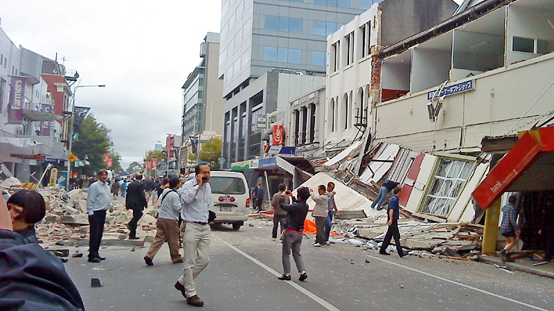 People walk through a street partly covered with rubble after an earthquake hit Christchurch, New Zealand, Tuesday, Feb. 22, 2011. (AP / Xinhua, Pu Rui)