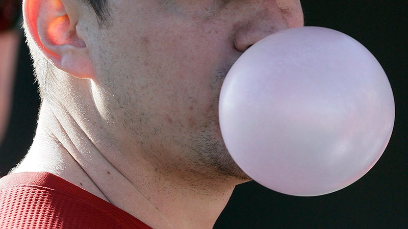 Man chews bubble gum and blows bubble