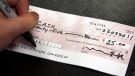 A man is seen writing a cheque in this 2011 file photo. (Ryan Remiorz/THE CANADIAN PRESS)