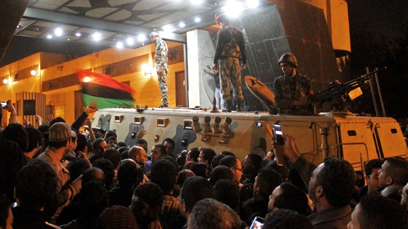 Egyptian soldiers atop an armored vehicle stand at the entrance of the state security headquarters as protesters storm the building in Cairo's northern Nasr City neighborhood, Egypt, Saturday, March 5, 2011. (AP / Ahmed Ali)
