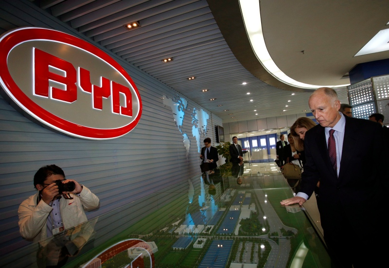 California Gov. Jerry Brown walks past a logo of BYD during a visit at the Chinese automaker's headquarters in China's southern city Shenzhen,Tuesday, April 16, 2013. (AP Photo/Vincent Yu)