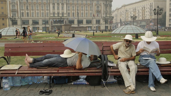 People rest on the Manezhaya Square just outside the Moscow Kremlin, Monday, Aug. 9, 2010, enjoying the brief respite from the smog due to a change in the wind direction. (AP Photo/Ivan Sekretarev)