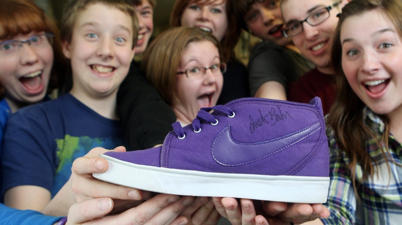 The communications club hold an autographed Justin Bieber running shoe held by student Jessica Eaton, at Bieber's former school, Northwestern Secondary School in Stratford, Ontario, Wednesday, March 9, 2011. (Dave Chidley / THE CANADIAN PRESS)   