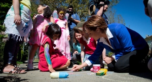British Columbia Premier and Liberal Leader Christy Clark, right, uses chalk to draw a picture of her cat Pixie on the sidewalk after stopping to talk to young girls after a provincial election campaign stop at the house next door in Vancouver, B.C., on Sunday May 5, 2013. THE CANADIAN PRESS/Darryl Dyck