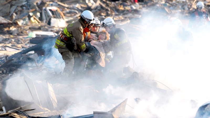 A resident is rescued from debris in Natori, Miyagi, northern Japan, Saturday, March 12, 2011. (AP / Asahi Shimbun, Noboru Tomura)