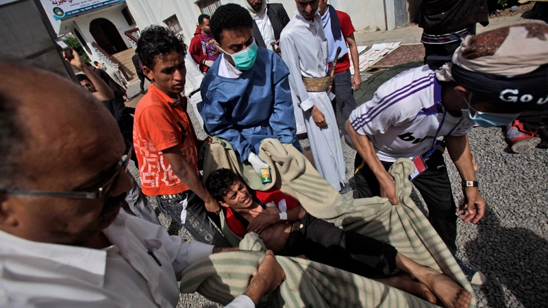 Anti-government protesters carry an injured protester into the yard of a Mosque for help following clashes with Yemeni police in Sanaa, Yemen, Saturday, March 12, 2011. (AP / Muhammed Muheisen)