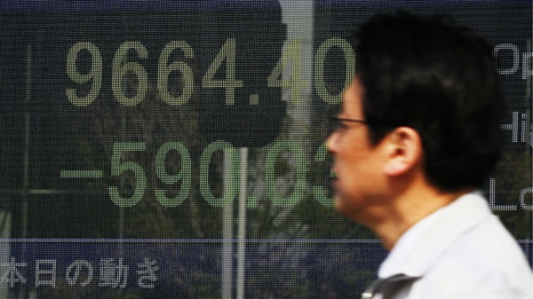 A man watches a stock price board on a street Monday, March 14, 2011 in Tokyo, Japan. 