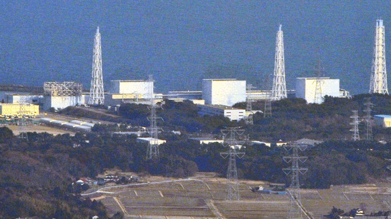 Unit 1 reactor of the Fukushima Daiichi Nuclear Power Plant, left, with its top part of walls blown off after Saturday's explosion is seen with other units including Unit 3 reactor, second from right, where a hydrogen explosion could occur in Okumamachi, Fukushima Prefecture in Japan, Sunday, March 13, 2011. (AP / Kyodo News, Masaru Nishimoto) 