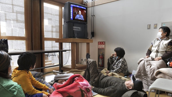 Victims watch Japanese Prime Minister Naoto Kan on TV in a live broadcast at an evacuation center at Kawamata, northeastern Japan, on Tuesday March 15, 2011. (AP / Kyodo News) 