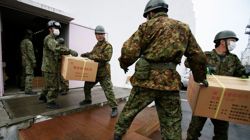 Japan's Self-Defense Force's members unload supplies for evacuees Tuesday, March 15, 2011, in Soma city, Fukushima prefecture, Japan. (AP / Wally Santana)