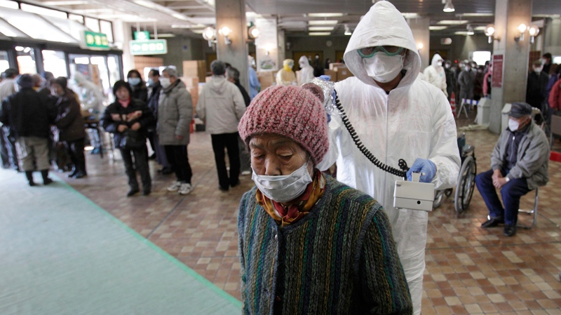A woman is scanned for radiation exposure at a temporary scanning center for residents living close to the quake-damaged Fukushima Dai-ichi nuclear power plant in Koriyama, Fukushima Prefecture, Japan, Wednesday, March 16, 2011. (AP / Gregory Bull)