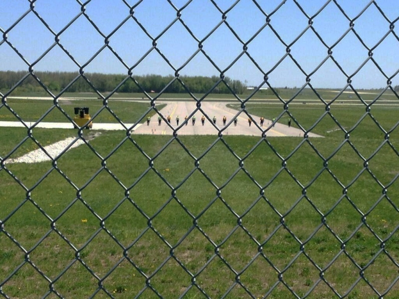 Police are seen along an airstrip leading to a Millard Air hangar at the Region of Waterloo International Airport on Thursday, May 16, 2013. (Nicole Lampa / CTV Kitchener)