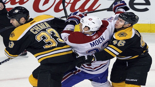 Montreal Canadiens left wing Travis Moen (32) is sandwiched between Boston Bruins defenseman Zdeno Chara (33), of the Czech Republic, and center David Krejci (46), of Czech Republic, during the first period of an NHL hockey game in Boston Thursday, March 24, 2011. (AP Photo/Elise Amendola)