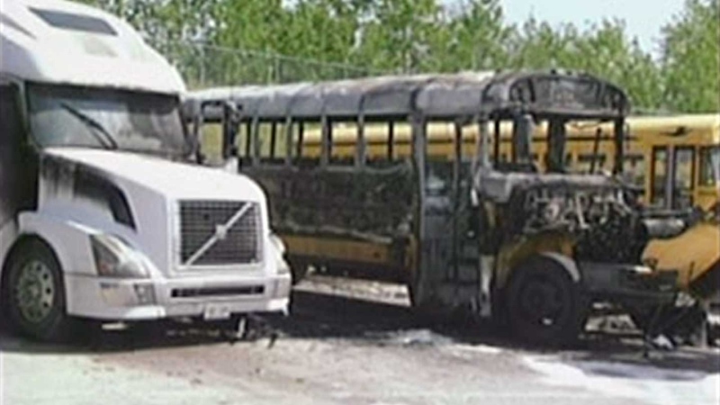 A school bus and transport truck seriously damaged by fire are seen in London, Ont. on Monday, May 20, 2013.