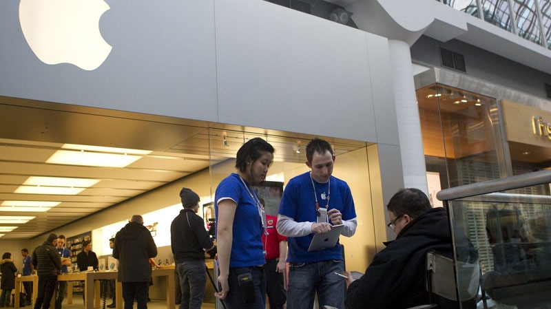 Staff members from the the Apple store in Toronto's Eaton Centre takes down the details of people at the front of the queue to purchase the new iPad 2 on Friday, March 25, 2011. (Chris Young / THE CANADIAN PRESS)