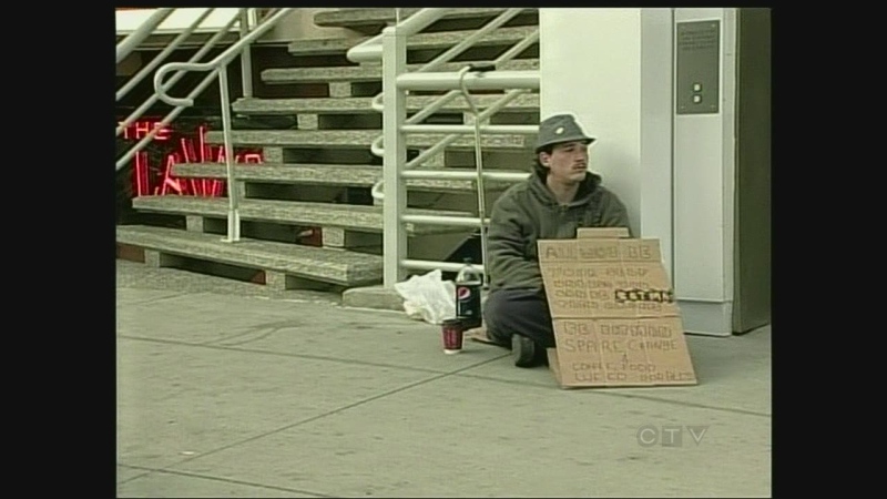 A Windsor panhandler sits on the sidewalk on Ouellette Avenue on Sunday, May 26, 2013.