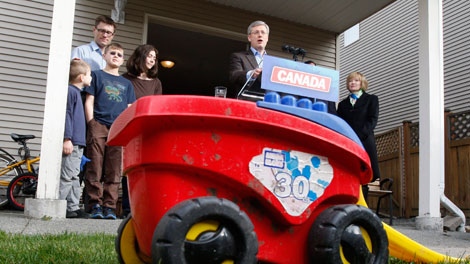 Prime Minister Stephen Harper speaks during a campaign stop in Saanich, B.C., Monday, March 28, 2011 as his wife Laureen (right) looks on with members of the Wellburn family, parents Tanya and Steve and sons Crispen and Gregory. THE CANADIAN PRESS/Adrian Wyld
