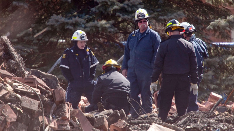 Investigators examine remains found in the rubble of an apartment building in Woodstock, Ont., Wednesday, March 30, 2011. (Geoff Robins / THE CANADIAN PRESS) 