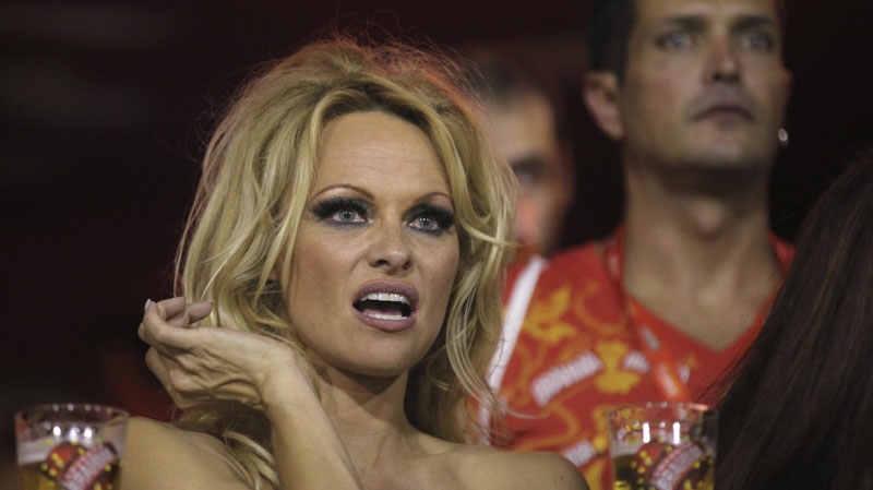 Pamela Anderson gestures from the stands as she watches a carnival parade at the Sambadrome in Rio de Janeiro, Brazil, Sunday March 6, 2011. (AP Photo/Silvia Izquierdo)