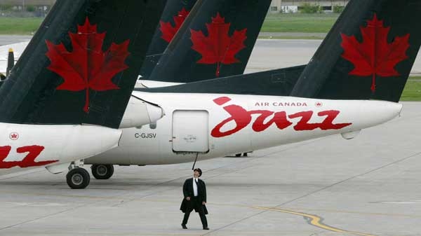 A pilot inspects his plane at the terminal for Air Canada's discount airline Jazz at Dorval airport in Montreal Friday, May 30, 2003.