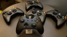 The controller for Microsoft's next-generation Xbox One entertainment and gaming console system is shown front and centre with older-generation controllers behind it, Tuesday, May 21, 2013, in Redmond, Wash. (AP / Ted S. Warren)