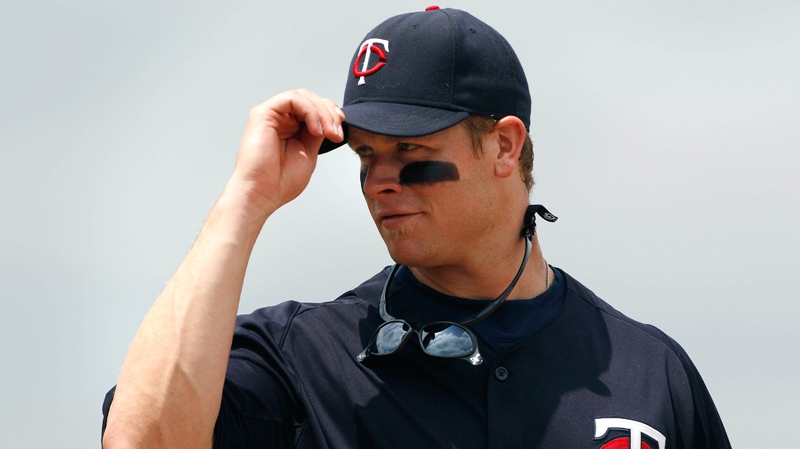Minnesota Twins first baseman Justin Morneau tips his cap as he looks into the Pittsburgh Pirates dugout during the second inning of a spring training baseball game in Fort Myers, Fla., Monday, March 28, 2011. (AP / Charles Krupa)