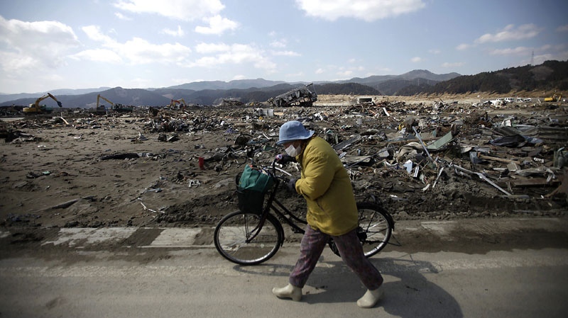 A woman pushes her bicycle at the March 11 earthquake and tsunami devastated area in Rikuzentakata, Iwate Prefecture, northern Japan Friday, April 1, 2011. (AP Photo/Eugene Hoshiko)