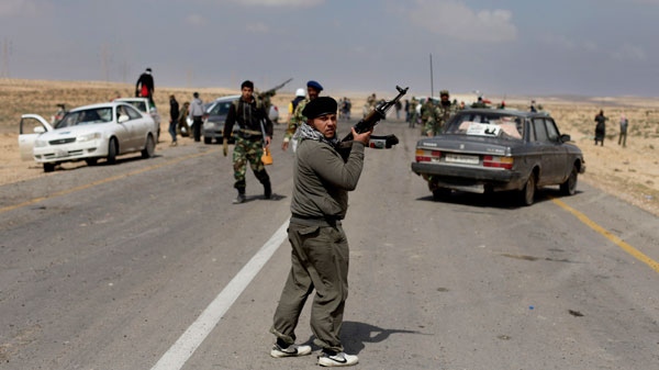 A Libyan rebel stands guard on the middle of the road at the front line near Brega, Libya, Saturday, April 2, 2011. (AP / Altaf Qadri)