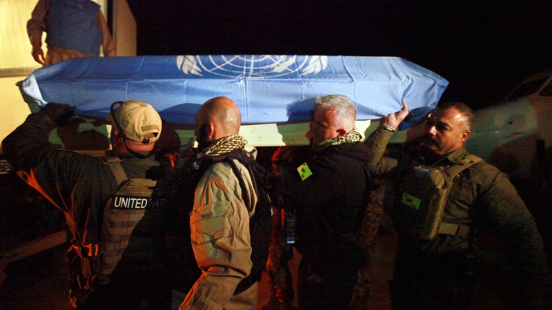 In this April 2, 2011 photo released by the United Nations, UN personnel carry the casket of one of seven colleagues killed in an attack on the UN operations center in Mazar-i-Sharif on Friday, April 1, at Kabul airport, Kabul, Afghanistan. (AP / UNAMA, Eric Kanalstein)