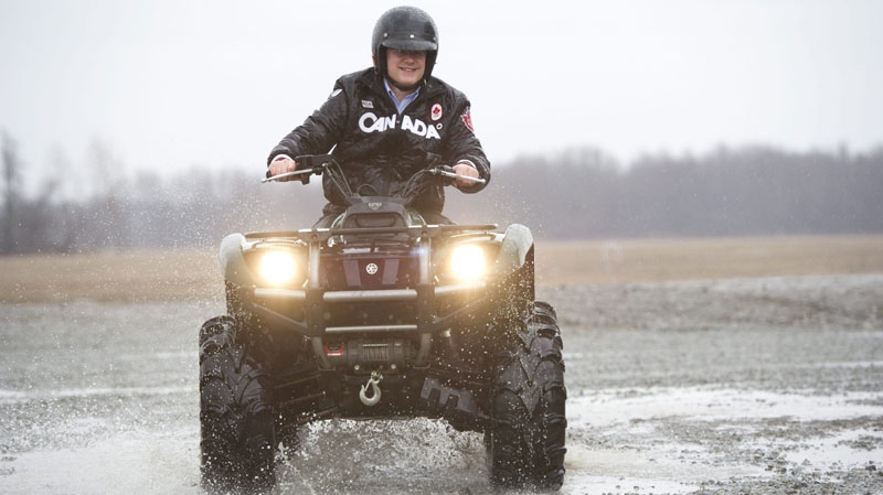 Prime Minister Stephen Harper rides an ATV during a camapign stop on a farm in Wainfleet, Ont., on Monday, April 4, 2011. (THE CANADIAN PRESS/Sean Kilpatrick)