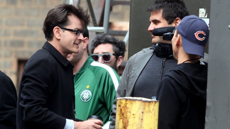 Charlie Sheen waves to fans after exiting his tour bus, in Detroit, Saturday, April 2, 2011. (Detroit Free Press / Eric Seals)