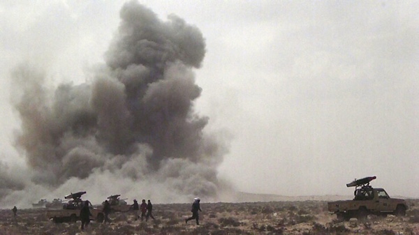 In this image made from television, a dust cloud is seen following the explosion of a missile, outside the strategic oil port of Brega, Libya, Thursday, April 7, 2011. (AP Photo/National Transitional Council in Libya via AP Television News)