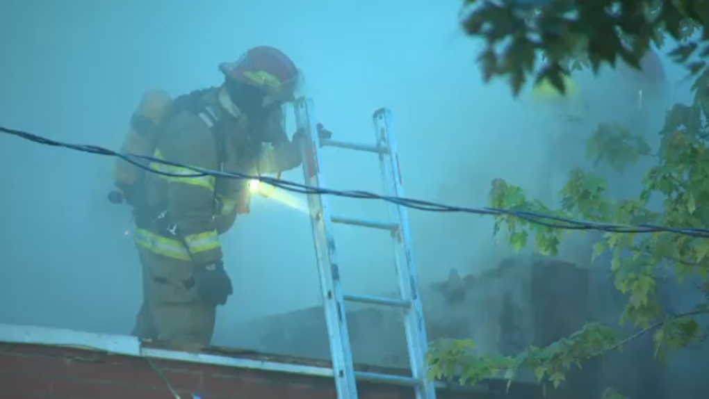 A firefighter peers through smoke