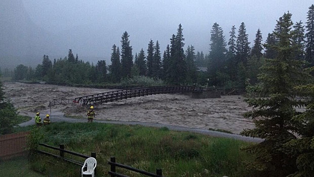 Fire crews are seen observing the swollen Cougar Creek in Canmore in this photo tweeted by the Canadian Rockies Public Schools.