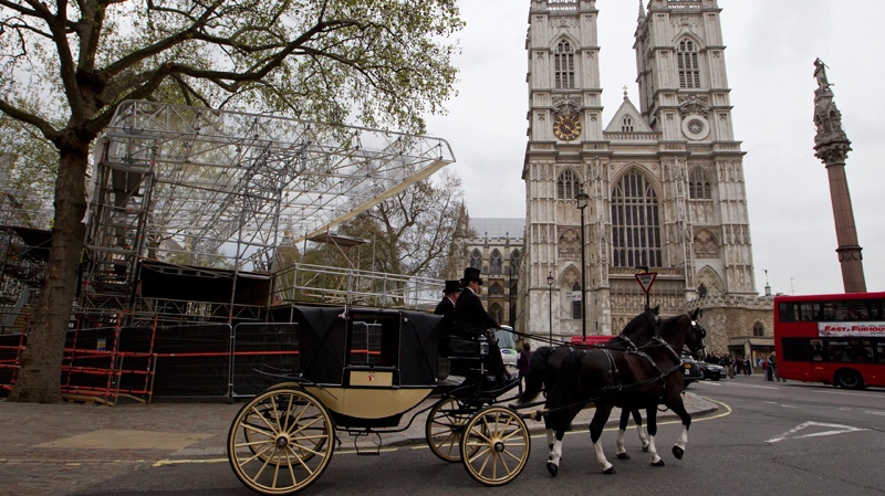 A horse drawn carriage drives pass a media stand, left, in readiness for the royal wedding, outside Westminster Abbey, right, in London, Thursday, April 14, 2011. (AP / Sang Tan) 