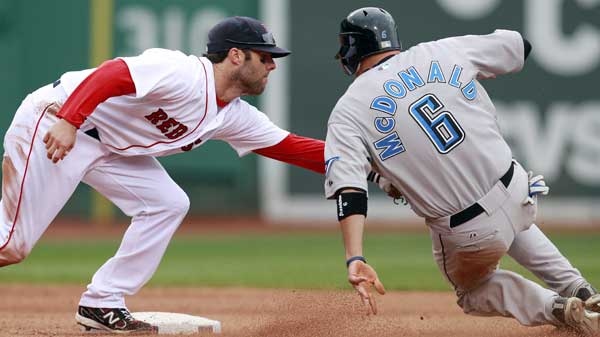 Boston Red Sox's Dustin Pedroia, left, tags out Toronto Blue Jays' John McDonald (6) trying to steal second base in the eighth inning of an MLB baseball game, April 16, 2011, in Boston. (THE ASSOCIATED PRESS / Michael Dwyer) 