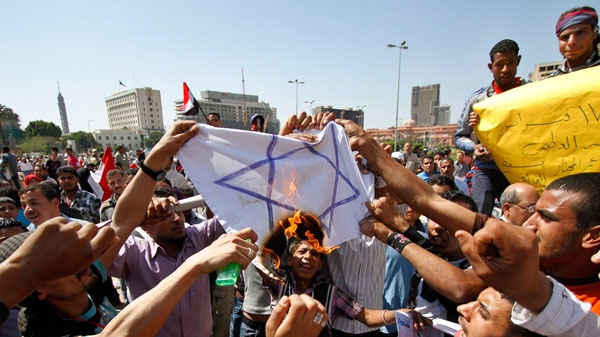 Egyptian protesters burn the Israeli flag as they demonstrate in Tahrir square in Cairo, Egypt, Friday, April 15, 2011. (AP / Khalil Hamra)