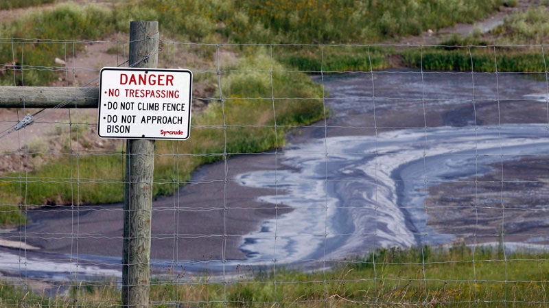 Tailings drain into a pond at the Syncrude oilsands mine facility near Fort McMurray, Alta., July 9, 2008. (Jeff McIntosh THE CANADIAN PRESS)