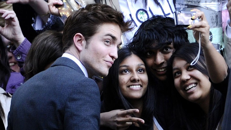 Actor Robert Pattinson takes pictures with fans at the premiere of "Water For Elephants" at the Ziegfeld Theater on Sunday, April 17, 2011, in New York. (AP Photo/Peter Kramer)