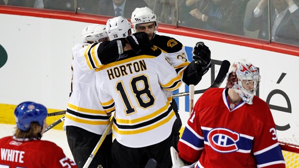 Boston Bruins right wing Nathan Horton (18) celebrates with teammates after he scored the second goal on Montreal Canadiens goalie Carey Price (31) as Canadiens Ryan White, left, look on during period of game three NHL Stanley Cup playoff hockey action Monday, April 18, 2011 in Montreal.THE CANADIAN PRESS/Ryan Remiorz