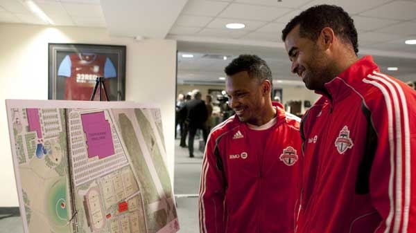 Toronto FC's captain Maicon Santos (right) and designated player Julian de Guzman look at a design presentation following a press conference in Toronto on Monday April 18, 2011 to announce the club's plans to develop a new Academy and Training facility at Downsview Park. (Chris Young / THE CANADIAN PRESS)
