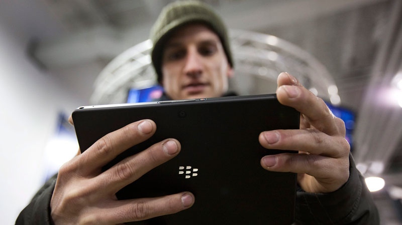 A customer plays with the Blackberry Playbook during the tablet's launch in Toronto Tuesday, April 19, 2011. (Darren Calabrese / THE CANADIAN PRESS)