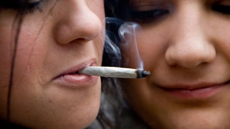 Yulia Dunajeva, left, and her roommate Cara Colcleugh share a marijuana joint outside the Vancouver Art Gallery in downtown Vancouver, Tuesday, April 20, 2010. The event is to promote the use of marijuana in Canada. THE CANADIAN PRESS/Jonathan Hayward