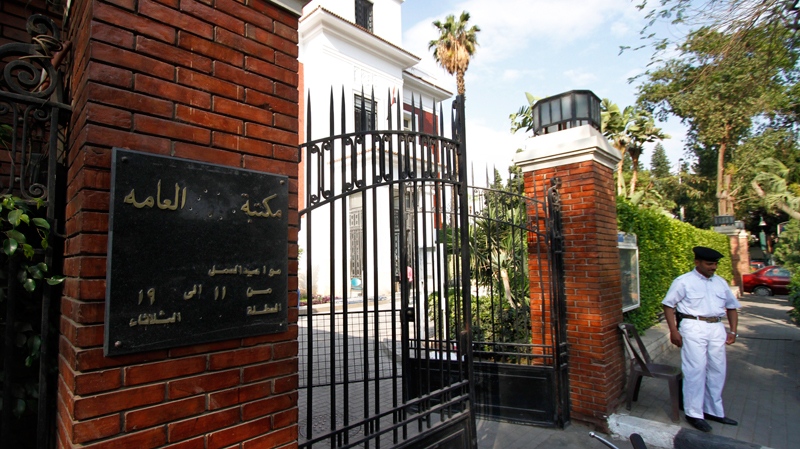 An Egyptian policeman guards the entrance of the Mubarak public library after Mubarak's name was removed from the sign, left, in Cairo, Egypt, Thursday, April 21, 2011. (AP / Khalil Hamra)