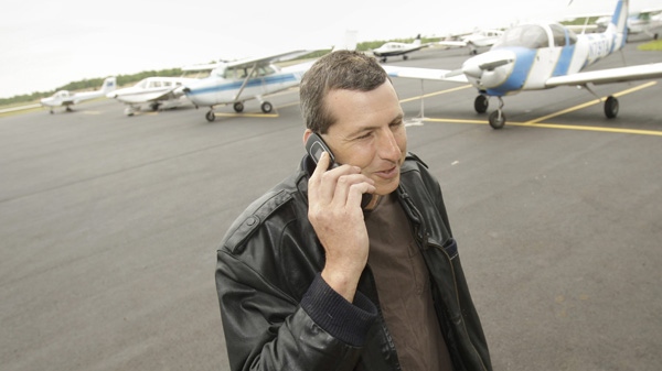 Commercial pilot Bill Phillips uses his cellphone on the tarmac at North Little Rock municipal Airport in North Little Rock, Ark., Wednesday, April 20, 2011. Phillips is representative of a trend of abandoning landline phones in favor of cellphones. (AP Photo/Danny Johnston)