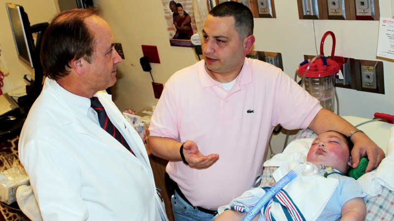 In this photo provided by SSM Cardinal Glennon Children's Medical Center Moe Maraachli, centre, with his son Joseph, reviews discharge plans with Dr. Robert Wilmott Thursday, April 21, 2011, at the St. Louis hospital. (AP / SSM Cardinal Glennon Children's Medical Center, Mary Aita)